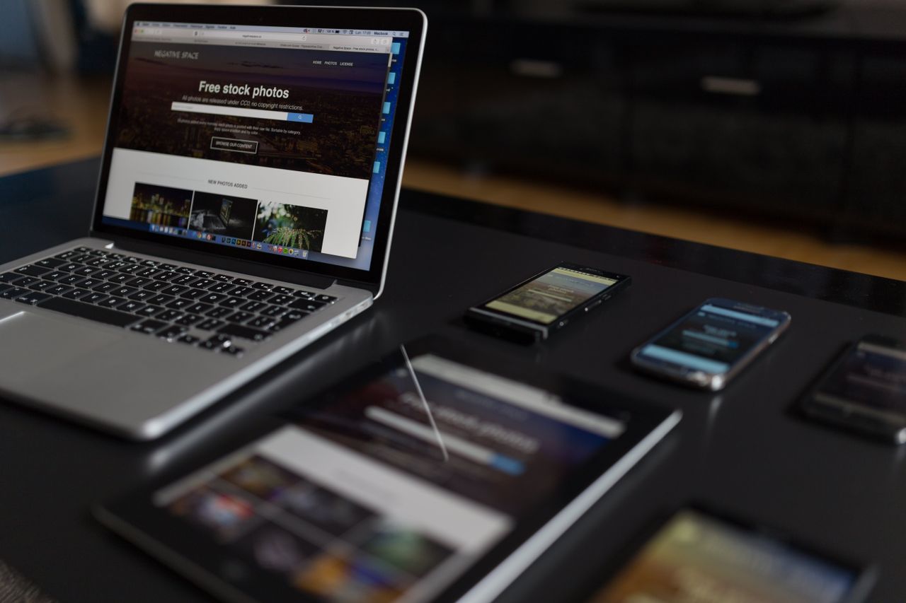 Un espace de travail contemporain mettant en avant un ordinateur portable, une tablette et des smartphones, idéal pour un usage tech et freelance.